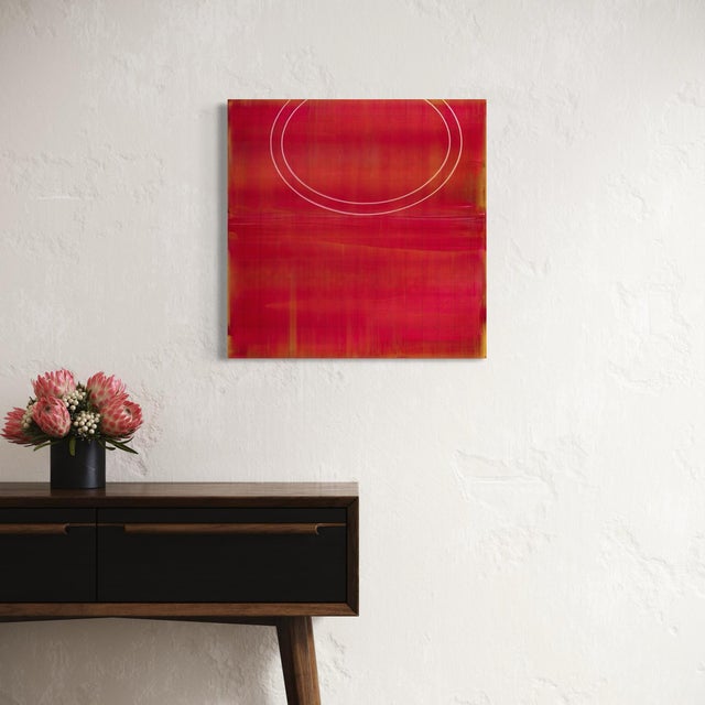 Two faint concentric circles trace themselves across a rich field of crimson and burgundy, the paint applied in soft,...