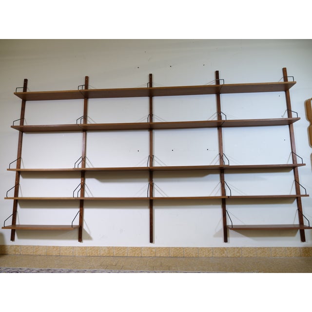 Modular ROYAL shelving system in teak by Poul Cadovius, 1960s. Wall-mounted wooden struts with pre-drilled holes, 19 teak...