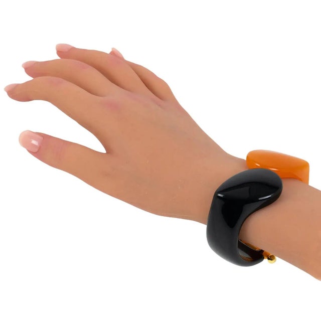 This gorgeous Italian designer Angela Caputi resin clamper bracelet features a contrasting black and orange shape with a...