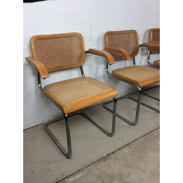 This set of three mid century modern dining chairs in the style of Marcel Breuer feature chrome chair frames with hardwood...