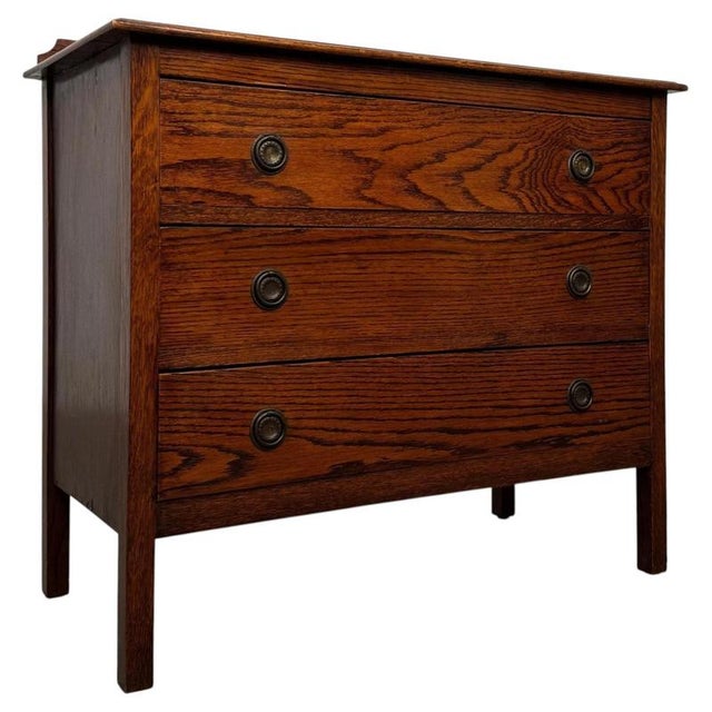 A handsome and beautifully proportioned early 20th-century English Edwardian chest of drawers, finely constructed in oak...