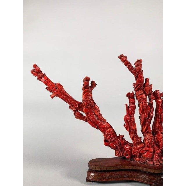 Large coral sculpture, early 20th century China, depicting sages and children surrounding a seated old man holding a fan....