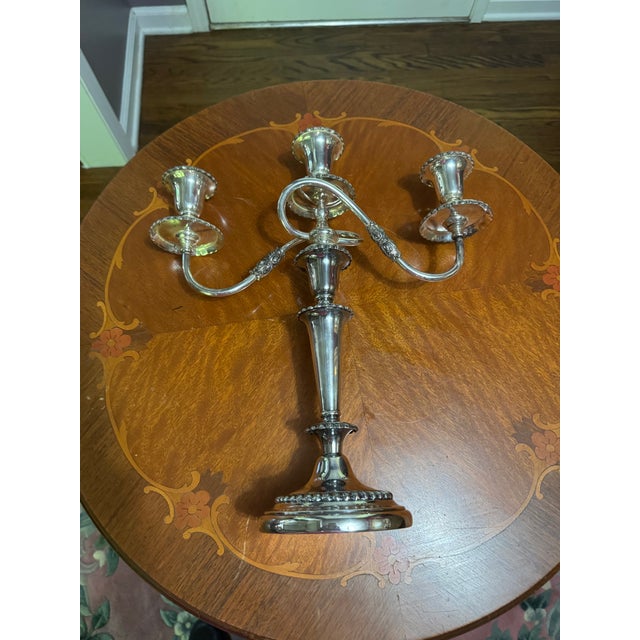 This silver-plated candelabra features a twisted arm design reminiscent of antique Old Sheffield plate styles. Three...