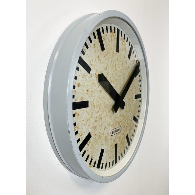 Benzing wall clock was made in Germany during the 1960s. It features a grey iron frame, a metal dial, an aluminium hands...