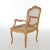 An antique French Louis XV style arm chair offers carved fruitwood frame having floral crest over caned seat and back,...