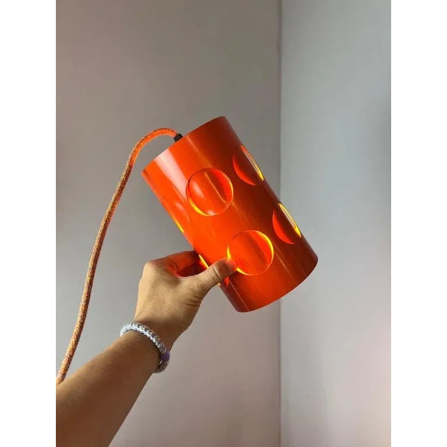 The orange metal pendant lamp from Raak Amsterdam is a striking example of Space Age design. The cylindrical shade...