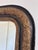 This antique French Louis Philippe mirror dates from the 19th century and showcases a black and gold frame with raised...