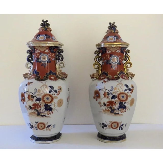 Pair of large Ironstone lidded urns in Imari colors. Marked on the bases. Retailed by Mortlock who employed other firms to...