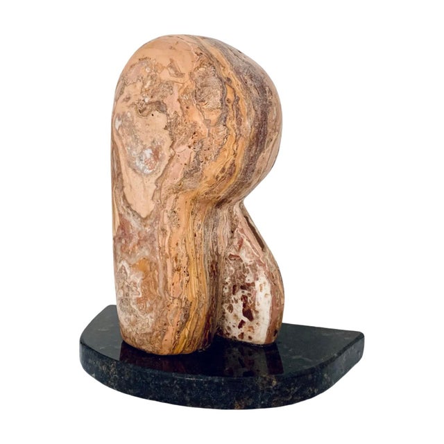 Vintage mid-century modern abstract sculpture carved in warm-toned travertine and mounted on a polished dark granite base....