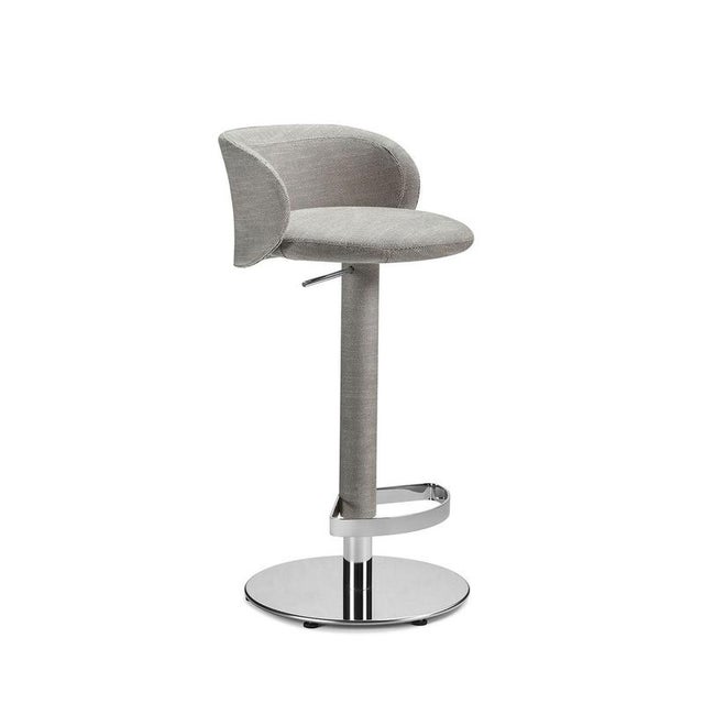 Designed by Richard Hutten, this bar stool pairs a softly rounded upholstered shell with a tailored silhouette and a fluid...