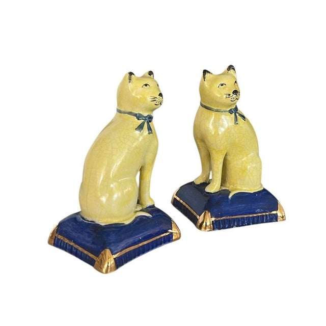 This charming vintage pair of small decorative ceramic figurines features two elegantly posed cats seated atop luxurious...