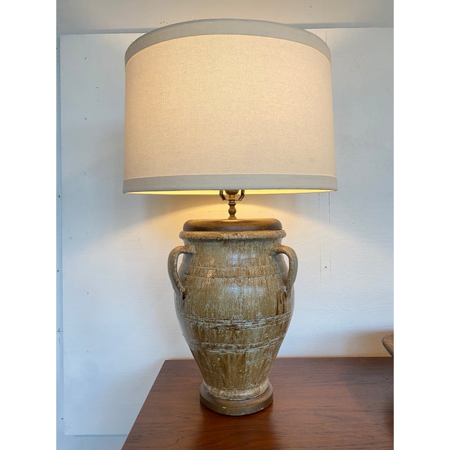 Olive and taupe glazed pottery table lamp. Features earth tone glaze and three handle at the side. Wood top and base.