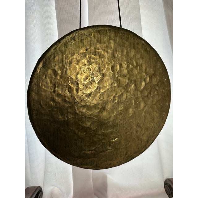 This antique English carved oak and brass dinner gong with barley twist legs is a unique and decorative piece that adds a...