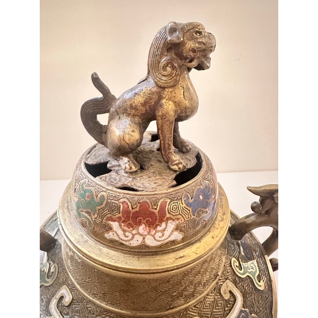A vintage bronze censer with rich cloisonné enamel decoration throughout, worked in blue, red, green, and white against a...