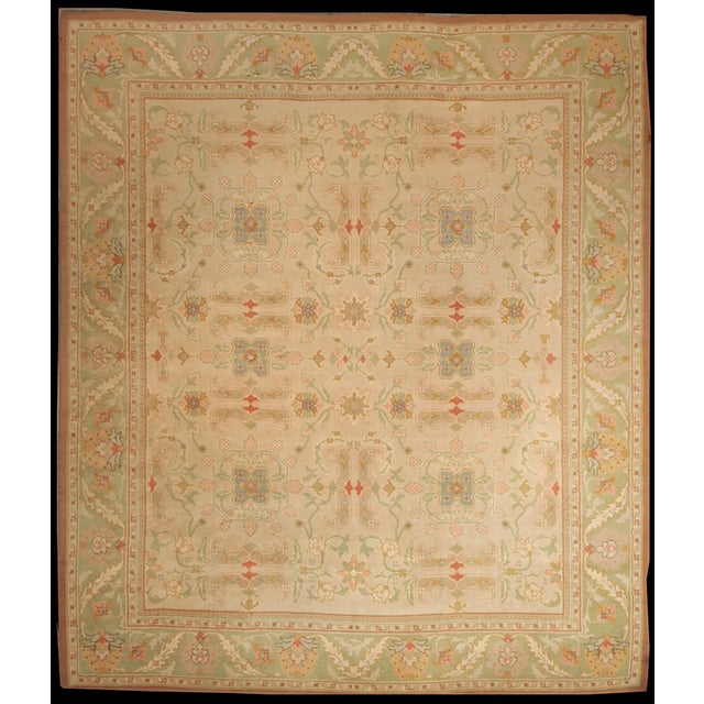 Hand-knotted in wool originating from Turkey circa 1950-1960, this 12x14 vintage rug connotes an Oushak design in a...