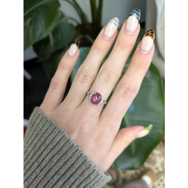 Stunning 6.7ct star ruby ring in solid 14K gold, featuring a 10×8 mm oval cabochon with natural diamond accents. Elegantly...