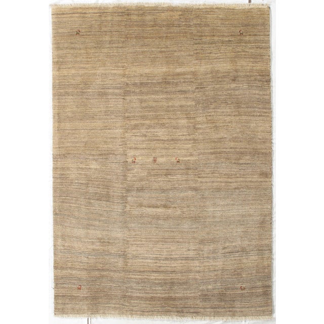 Vintage Hand-knotted Persian Lori Gabbeh rug featuring a warm, earthy field with fine horizontal striations in beige,...
