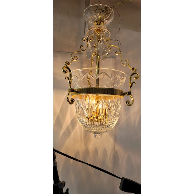 Vintage 1990s brass and crystal chandelier featuring a bell-jar bowl pendant with faceted prism drops. Elegant...