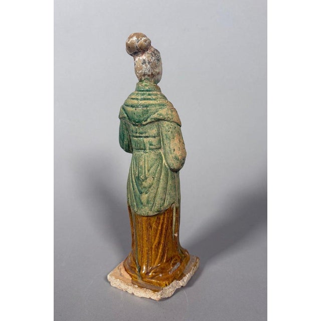 Sculpture of a Mingqi Servant, China, Ming Dynasty (1368-1644). Terracotta sculpture with green and brown glaze. Depicts a...