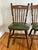 Pair of mid-20th century Virginia House Windsor-style oak chairs. Feature turned wood and cleanable green faux leather...