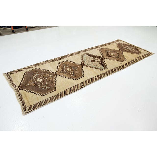 This is a handmade Persian Malayer rug from the 20th century. It features a beige field with brown and blue accents...