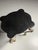 Elegant antique side table with a richly detailed, hand-carved base and a black marble top in a graceful, organic shape....