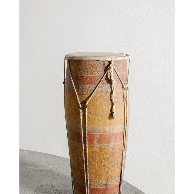 Beautiful and decorative tribal drum in wood with red stripes, strings and hide produced in Africa early 1900s. In good...