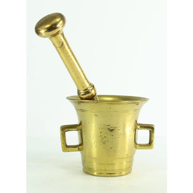 An impressive antique mortar and pestle set Made of heavy cast and shaved bronze or brass in a characteristic tapered form...