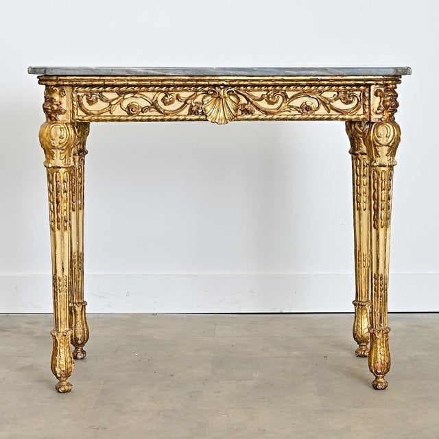 A dramatic 19th century Italian console table with an exquisite rococo giltwood base supporting its original, thick slab...