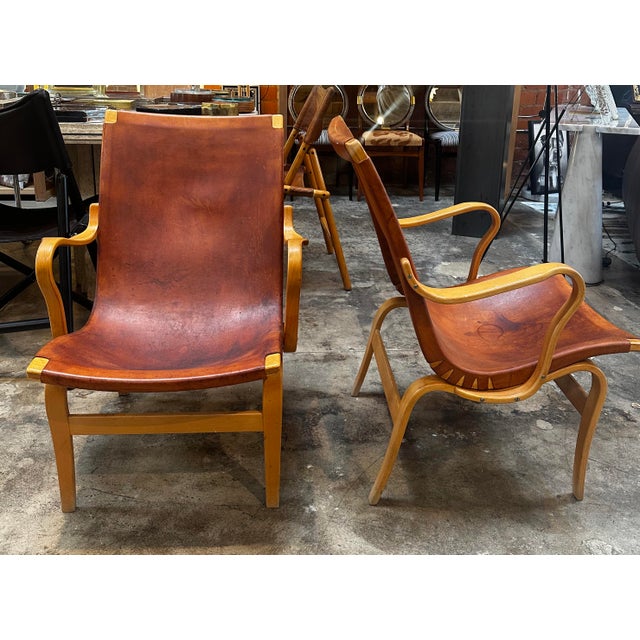 Rare pair of "Eva" easy chairs in beech and original cognac leather designed by Bruno Mathsson and produced by Firma Karl...