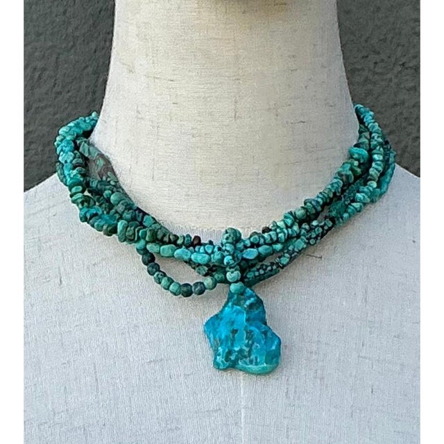 This striking vintage turquoise beaded multi-strand necklace blends timeless Southwestern charm with vibrant, organic...