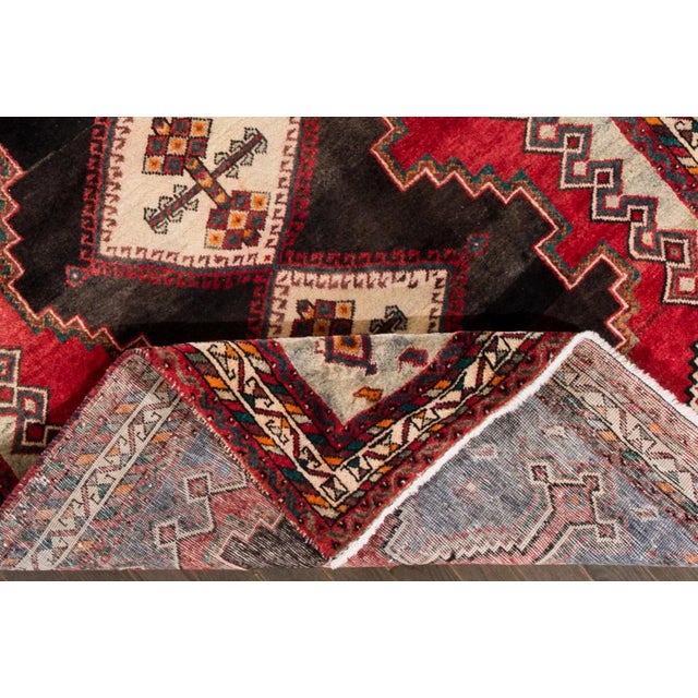 Beautiful Vintage Persian Handmade Wool Rug with a red field. This rug has multi-color accents in an allover geometric...