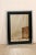 A sleek artisan-crafted rectangular wall mirror in a sophisticated black and antiqued glass surround. This nice-sized,...