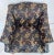 This imported Chinese satin brocade fabric features dragon and phoenix motifs across a dark sky. The primary colors are...