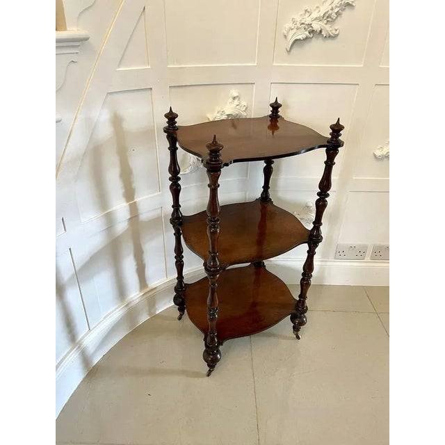 Antique Victorian freestanding rosewood whatnot having three serpentine shaped rosewood shelves supported by eight solid...