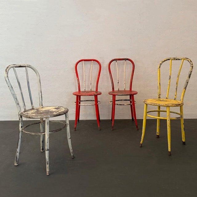 This is a set of four vintage American bent tubular steel café dining chairs. Each chair is lightweight and comprised of...