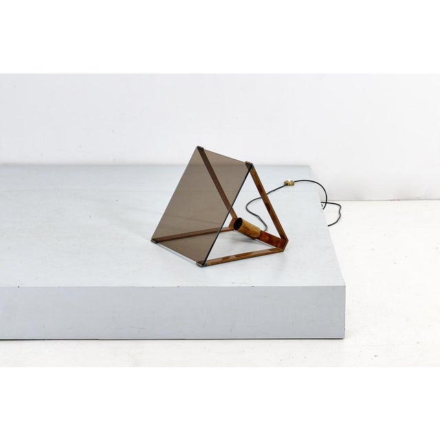 Rare and original geometric floor lamp with triangular section, structure in gilded brass and panel-diffuser in smoked...