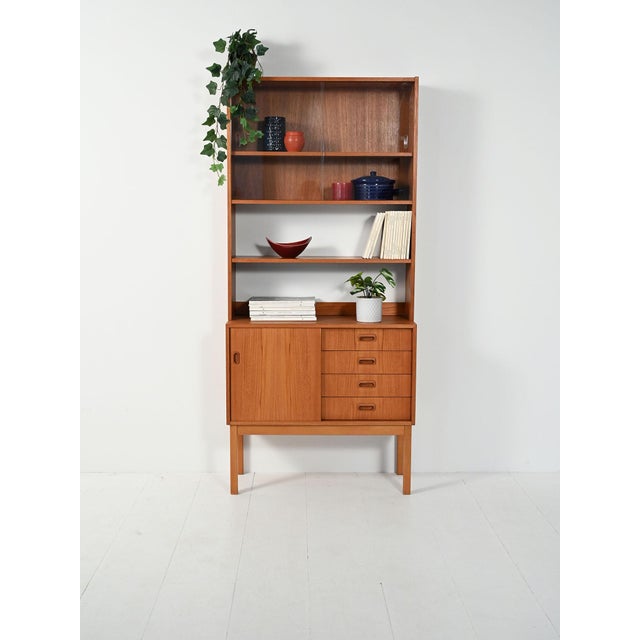 Scandinavian teak bookcase from the 1950s/1960s: base with sliding door and four drawers, upper section with open shelf...