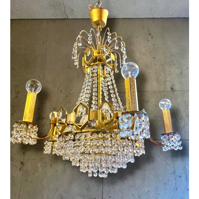 Very beautiful and richly executed vintage chandelier from the 1960s/70s, crafted in brass and fully fitted with cut prism...