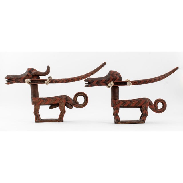 Pair of Bambara Chiwara Antelope Headdresses, Mali, carved wood with red paint, leather neckpieces, and string tufts on...