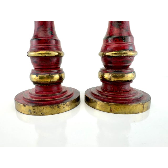 This striking pair of vintage turned wood candleholders showcases a richly layered red and green painted finish, accented...