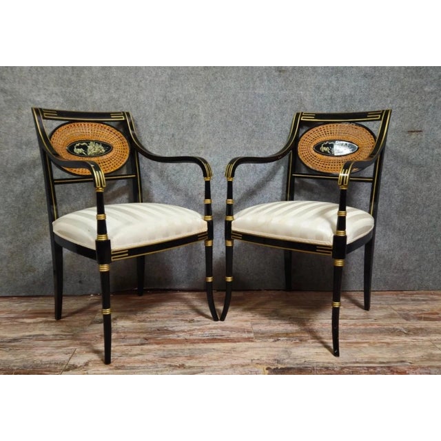 Elegant pair of Directoire-inspired armchairs, characterized by their simple, architectural lines. The structure is made...