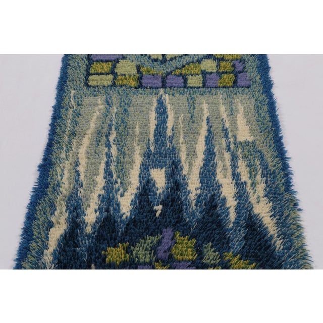 Hand-knotted in lush, high-pile wool in Sweden circa 1960-1970, this 2x5 vintage Swedish Rya rug is a bold new addition to...
