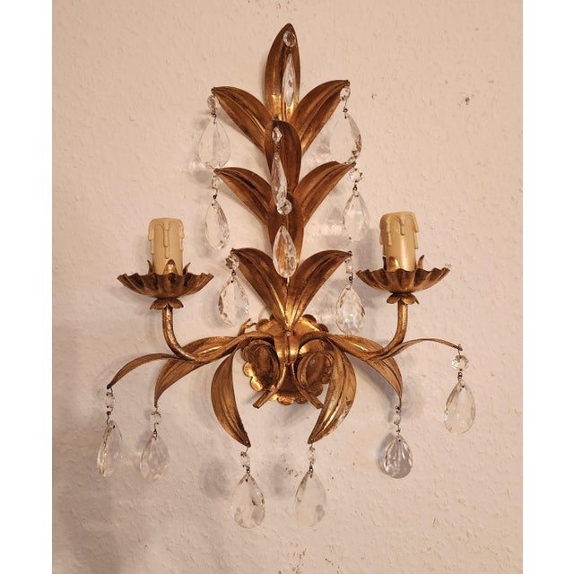 A stunning, hand-forged, handmade vintage wall sconce in a floral design, gilded in gold leaf with floral and leaf...