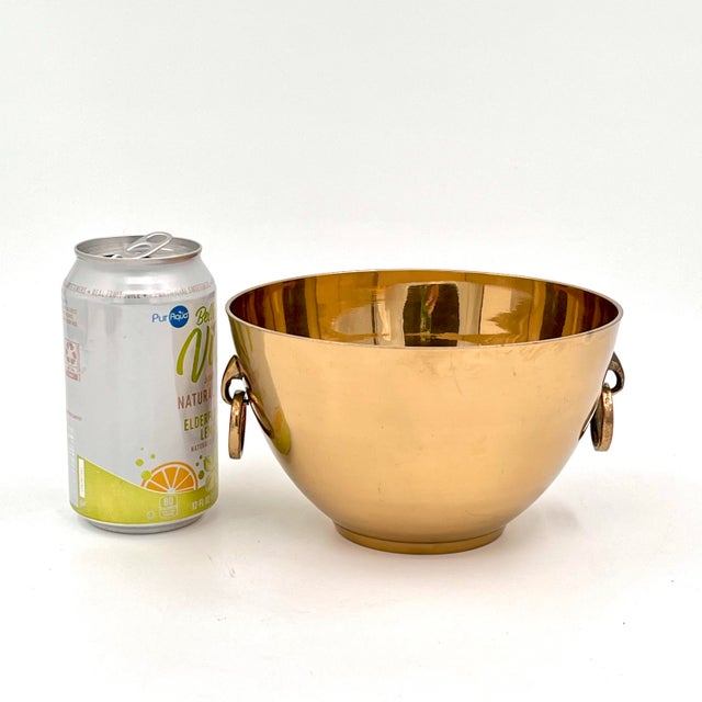 This vintage heavy brass bowl is a stunning piece, featuring "elegant head" rings on each side that add a touch of...