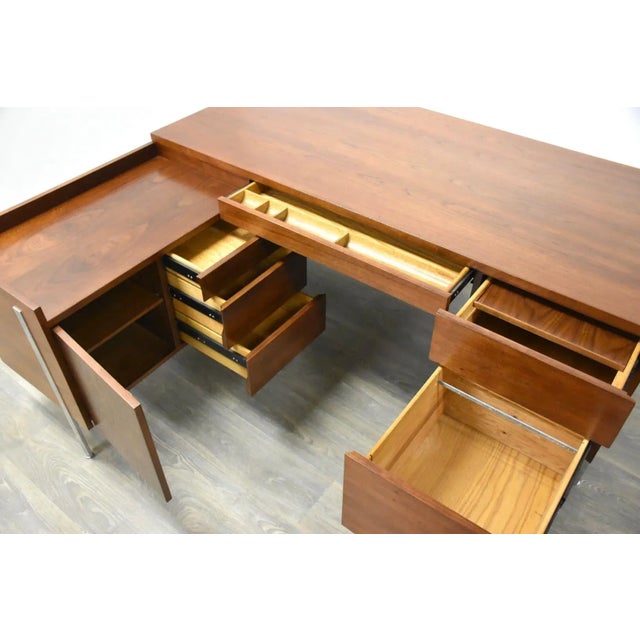 A mid century modern walnut L-Shaped desk with polished chrome legs and file hanging capabilities by Harvey Probber....