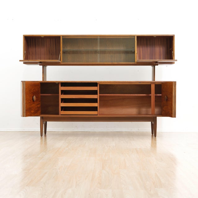 Exceptional British mid-century Elm credenza with matching raised display hutch. Featuring clean architectural lines,...