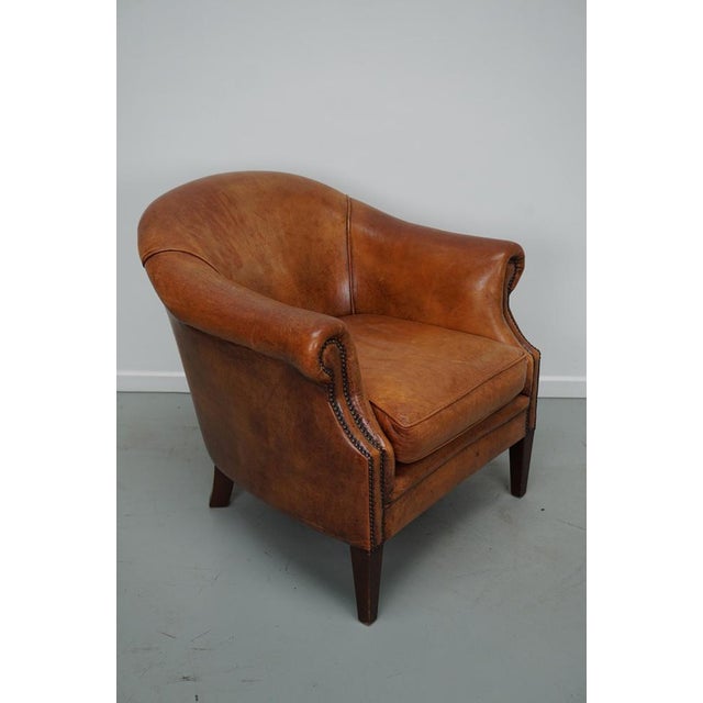 This cognac-colored leather club chair comes from the Netherlands. It is upholstered with cognac-colored leather and...