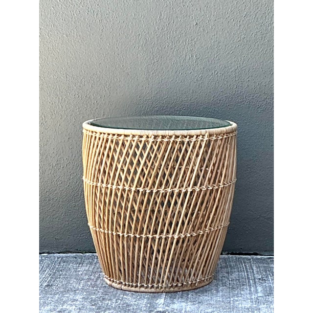 Bring organic texture and a relaxed, coastal sensibility to your living space with this vintage round rattan side table. A...