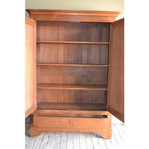 19th-century French oak cabinet. The height is 211 cm. The width is 150 cm. The depth is 57 cm. Behind the two doors....